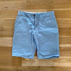 Men’s flat front chino shorts, light blue.